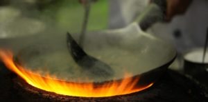 Closeup shot of a chief making a delicious dish for the guests in a pot