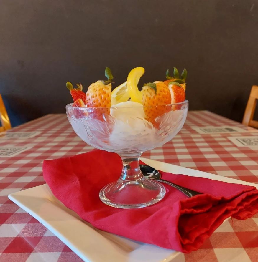 Lemon gelato with slices of strawberries. 