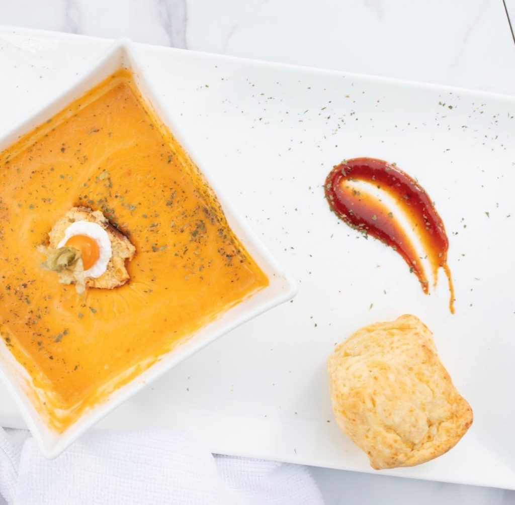 Beautifully plated pumpkin soup with bread for dipping.
