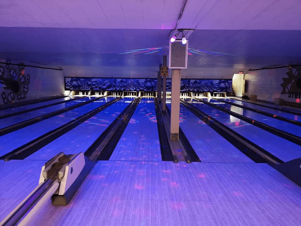 Bowling alleys lit with purple lighting for glow bowling.
