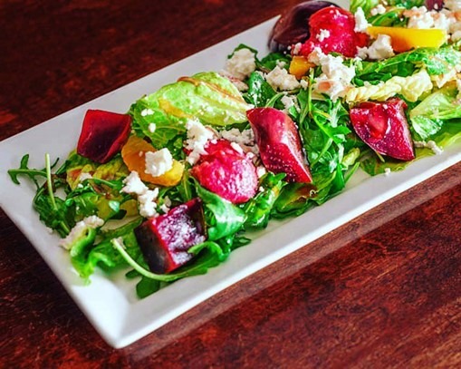 Colourful beet salad with mixed greens.
