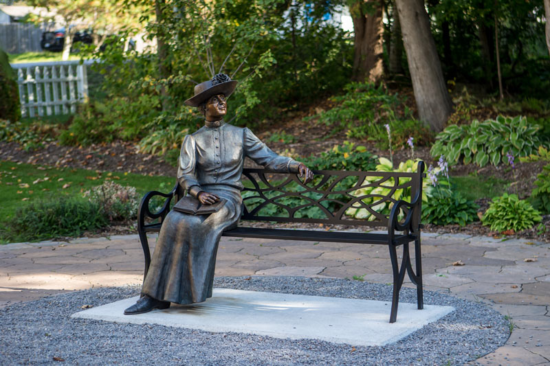 Lucy Maude Montgomery sculpture on park bench.