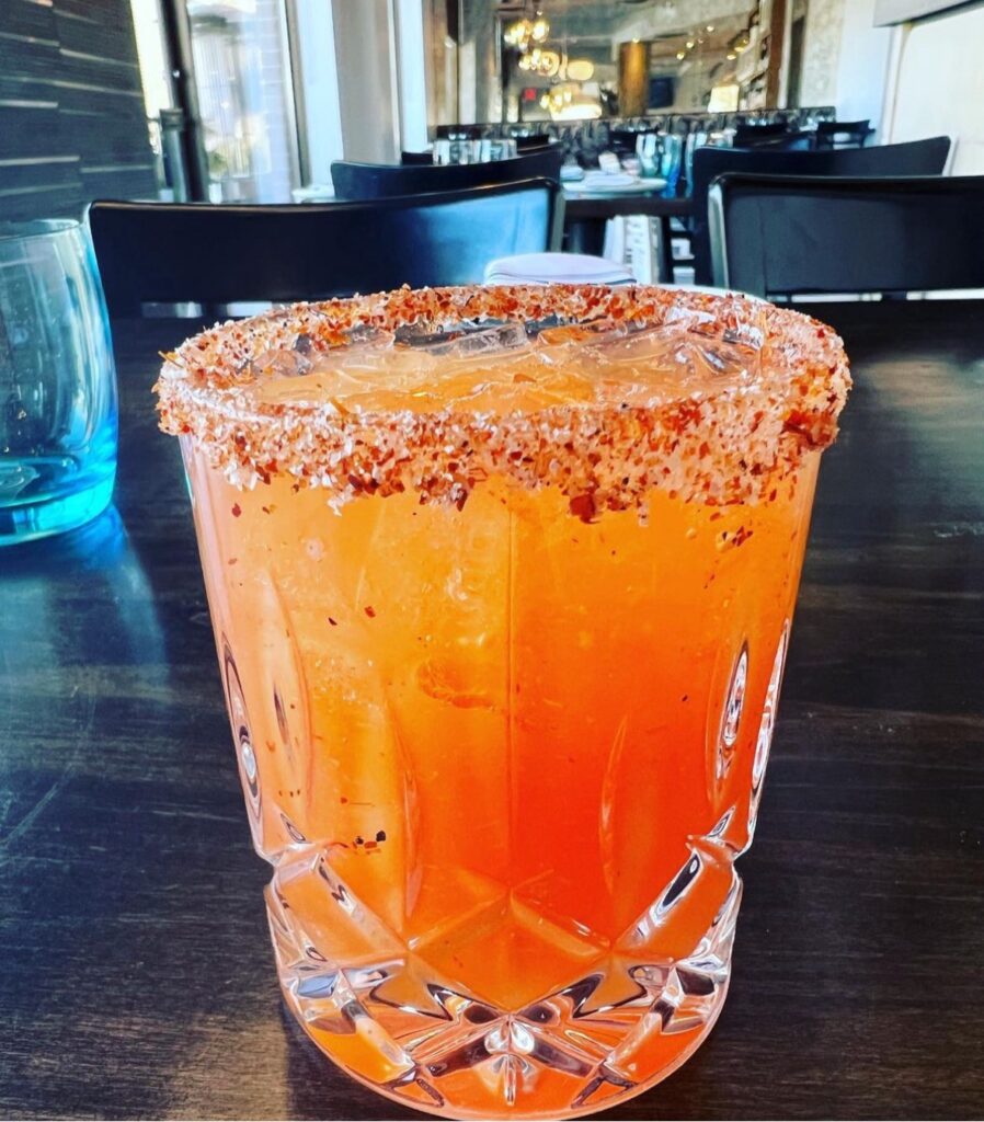 Bright orange cocktail with an orange salted rim at Urban Pantry.