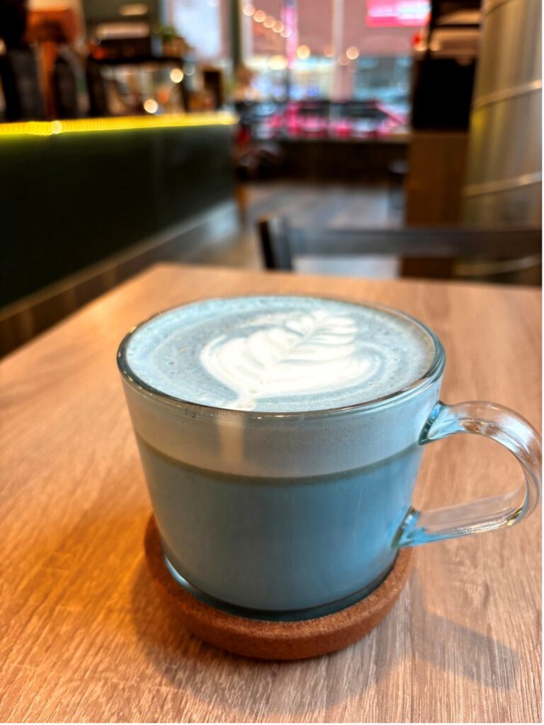 Close up of a Vanilla Blue Latte with a design on top at Nexus Coffee.