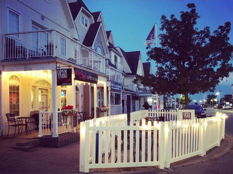 Beautiful exterior and patio with a white picket fence at the Open Art Studio and Cafe.