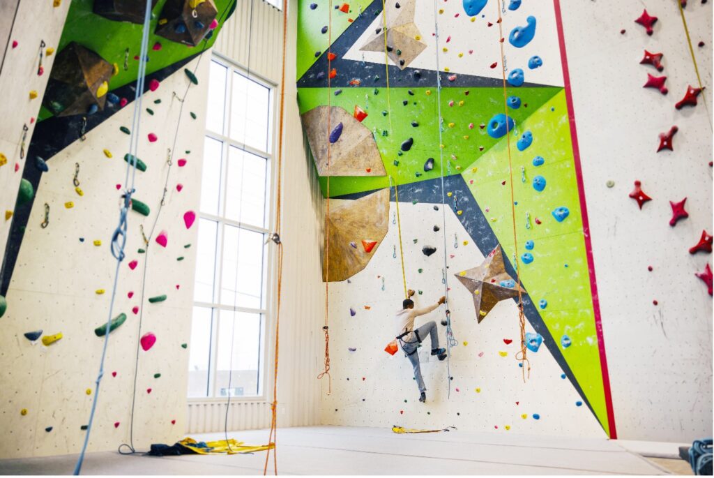 Person rock climbing indoors at Pinnacle Indoor Rock Climbing.